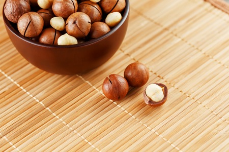 Macadamia nut on bamboo texture, concept of superfoods and healthy food. Overhead or top view shotの写真素材