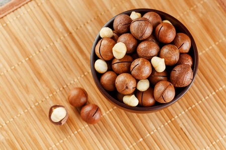 Macadamia nut on bamboo texture, concept of superfoods and healthy food. Overhead or top view shotの写真素材