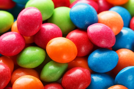Rainbow colors of multicolored candies close-up, texture and repetition of dragee. Backgroundの写真素材