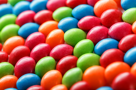 Rainbow colors of multicolored candies close-up, texture and repetition of dragee. Backgroundの写真素材