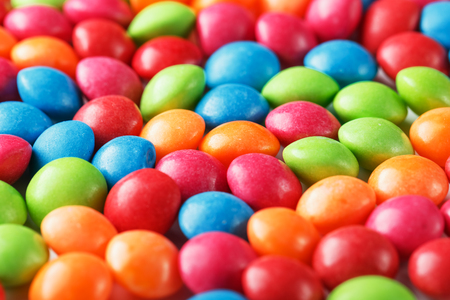Rainbow colors of multicolored candies close-up, texture and repetition of dragee. Backgroundの写真素材