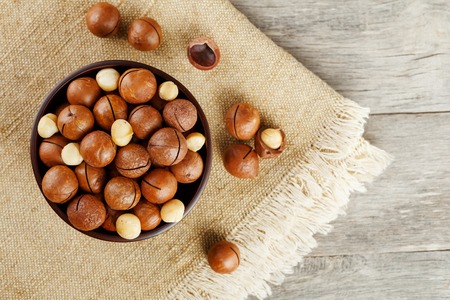 Macadamia nut on wooden background with vintage cloth, concept of superfoods and healthy food. Overhead costs or top view shotの写真素材