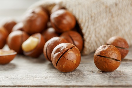 Macadamia nut on a wooden table in a bag, closeup, top view. Healthy productの写真素材