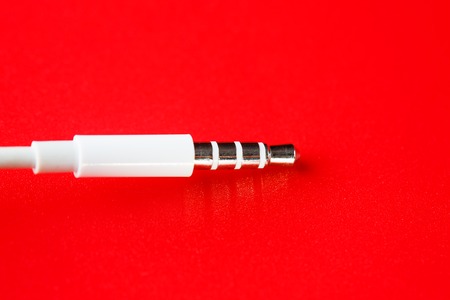 White connector auxiliary white cable on a red backgroundの写真素材