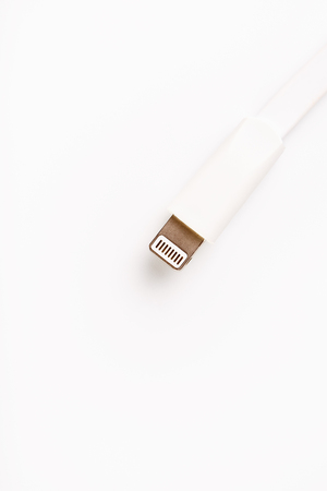 Connector lightning on a white background. This is a proprietary connector used to connect mobile devices to well-known host computers.の写真素材