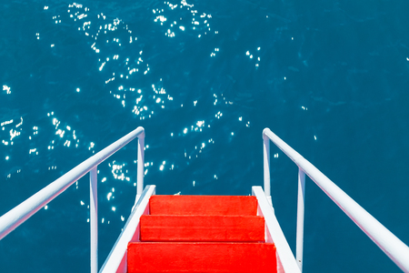The red staircase with white railings goes into the azure clear waters of the Black Seaの写真素材