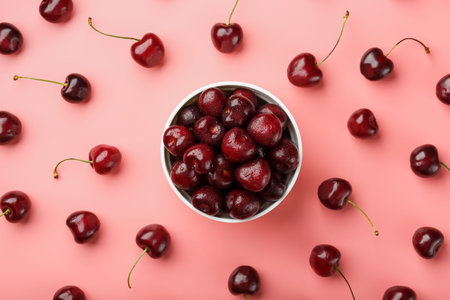 Cherry berry on a pink background in a white cup, top view. Concept of fertilization.
