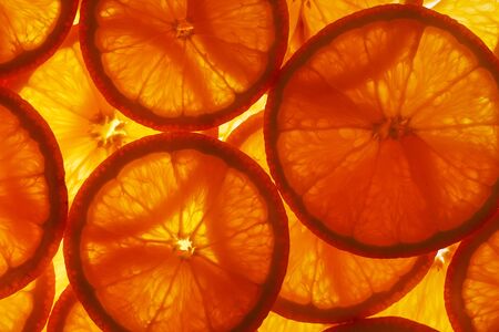 Slices of pulp and zest ripe orange with backlighting as a textural background, the substrate. Full screen, Close-up, macroの写真素材