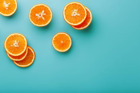 Slices and slices of orange pulp on a bright blue background as a textural background, the substrate. Full screen Flat lay, top view. Food background. Citrus pattern. Pop art, flat lay, top viewの写真素材