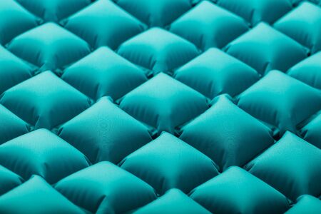 Texture of a blue inflatable tourist rug, repeating sections and patterns. Air mattress Ultralight Portable rug. tpu material Close-up top viewの写真素材