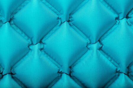 Texture of a blue inflatable tourist rug, repeating sections and patterns. Air mattress Ultralight Portable rug. tpu material Close-up top viewの写真素材
