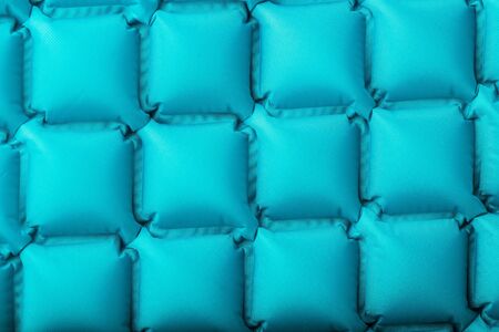 Texture of a blue inflatable tourist rug, repeating sections and patterns. Air mattress Ultralight Portable rug. tpu material Close-up top viewの写真素材