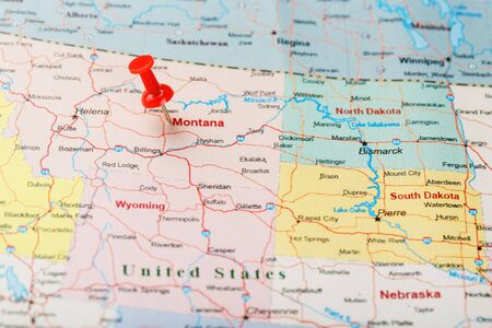 Red clerical needle on a map of USA, Montana and the capital of Helena. Close up Montana map with red tack US map pinの写真素材