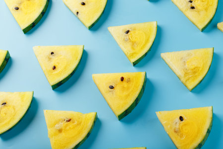 Summer pattern of yellow fruit watermelon slices on a light blue background. Minimal summer concept....