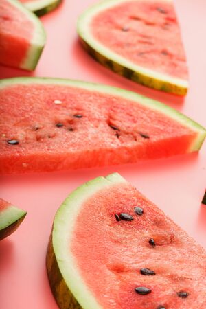 Red watermelon on pastel pink background. Summer concept. Watermelon pattern. Flat lay, top viewの写真素材