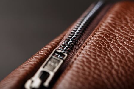 Brown backpack made of textured brown leather on a black stone background. Elegant golden brown women backpack with fashion and rivets. Genuine leather, handmade.の写真素材