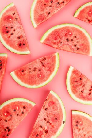 Juicy slices of red watermelon on a bright pink background. Conceptual colors of summer. Patterns top view as a background or substrate, wallpaperの写真素材