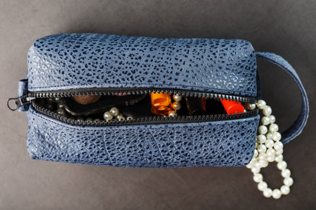 Bag for cosmetics and jewelry made of genuine dark blue leather, on a dark background. Handwork,...