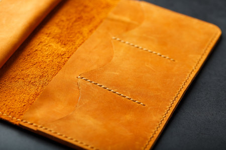 Brown purse, wallet made of genuine leather Nubuck on a dark background. Elements of leather craft...