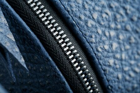 Lock and buckle close-up, elements of a blue backpack made of genuine leather on a dark background, handmade. Macroの写真素材