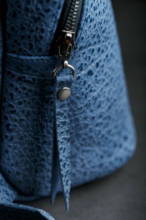 Lock and buckle close-up, elements of a blue backpack made of genuine leather on a dark background, handmade. Macroの写真素材