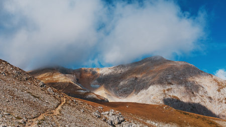 A route through mountain peaks and hills through majestic landscapes with tourists and travelers in...