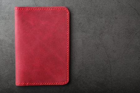 Red and pink leather cover in the background of tools and materials. The view from the top