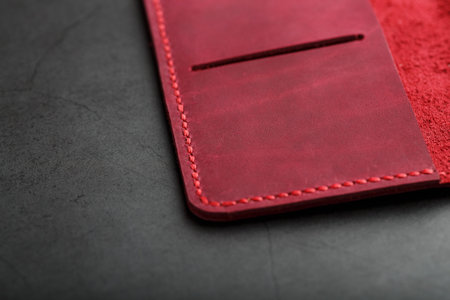Red leather cover for a passport on a dark background. Genuine leather, handmade, close up stitching. Close-upの写真素材