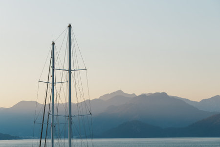 Ship mast on a background of blue sunset sky and mountains. The concept of sea adventures and travel