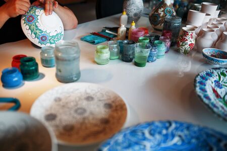 Painting porcelain plates with the hands of a professional craftsman. National Turkish craft.の写真素材