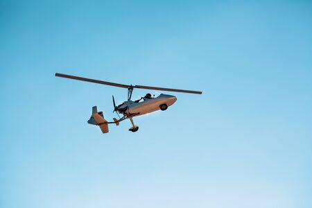 White small double gyroplane autogyro without a cabin against the blue sky. Air tours for tourists. Mini helicopterの写真素材
