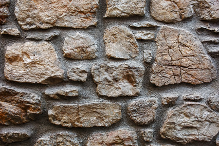 Textural background of cracked stone of an old castle. As a solid background, the substrate