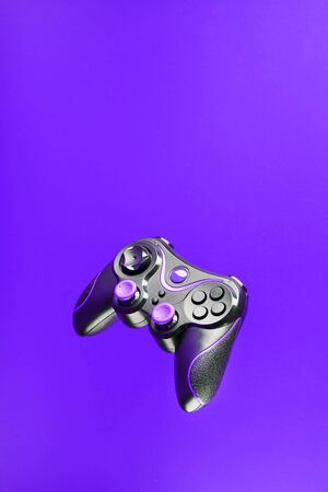 Game controller gamepad with pink buttons on lilac background. Device to control and control the game. Video games on PC, console, smartphone.の写真素材