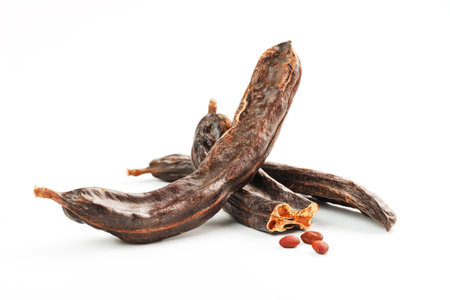 Carob carob fruit and seeds on white background. Isolate. Organic carob beans, a healthy alternative...