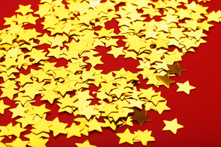 Gold stars on red background. The concept of greeting cards, headlines and web site. Top view,...