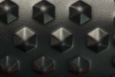 Black lumpy foam massage roller on red background. For the mechanical and reflex effects on tissues and organs. Close-up, texture, element in macroの写真素材