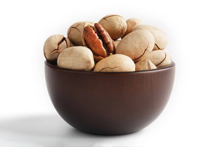 Pecan in a wooden Cup isolated on a white background.の写真素材