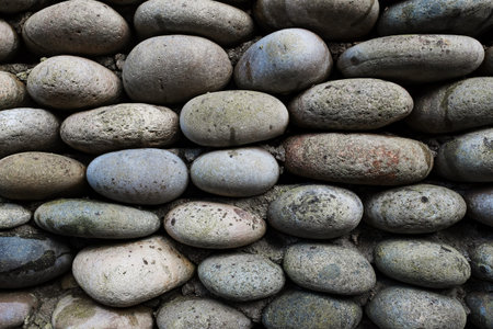 The texture of the stone wall, masonry of natural oval stones. As a full-screen background.