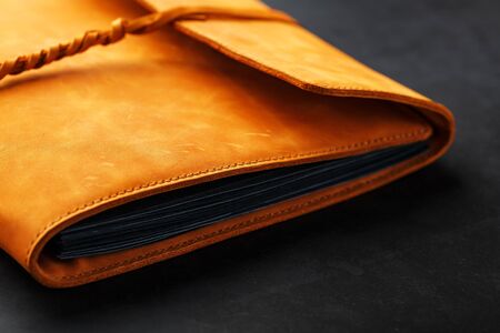 Photo album with blank black for photos. Split rings for close-up macro albums.The album cover is made of brown handmade genuine leather on a black background. Free space for text and photosの写真素材