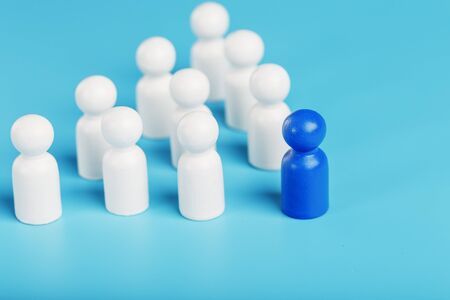 The leader in blue leads a group of white employees to victory, HR, Staff recruitment. The concept of leadership. A lot of employees are reaching for their boss. Personnel selection.の写真素材