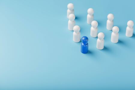 The leader in blue leads a group of white employees to victory, HR, Staff recruitment. The concept of leadership. A lot of employees are reaching for their boss. Personnel selection.の写真素材