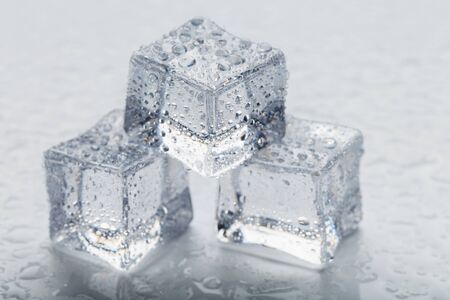 Ice cubes in the form of a pyramid with water drops close - up in macro on a white background. Refrの写真素材