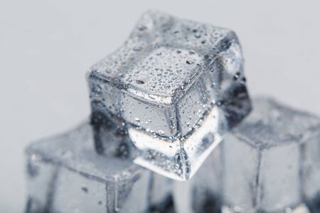 Ice cubes in the form of a pyramid with water drops close - up in macro on a white background. Refrの写真素材