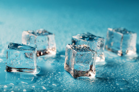 Ice cubes are scattered with water drops scattered on a blue background. Refreshing ice.