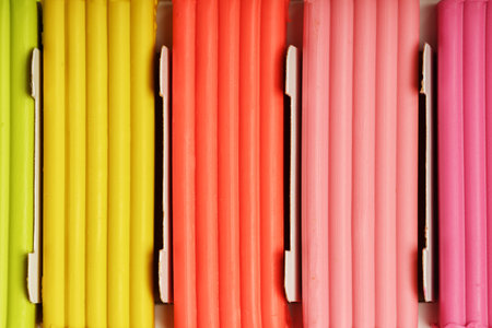 Plasticine in a box of multi-colored pieces in full screen, material for modeling. Close up.