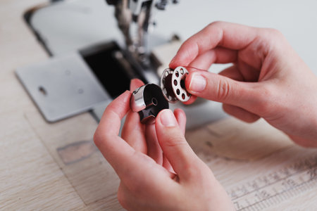 A leather craftsman produces leather goods on a sewing machine in his shop. Handmade work. Close up.