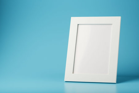 White and black photo frame with empty space on a blue background. Minimalistic concept with space...