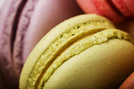 Macaron cookies with different color filling close-up, macro. French pastry made from egg whites,...