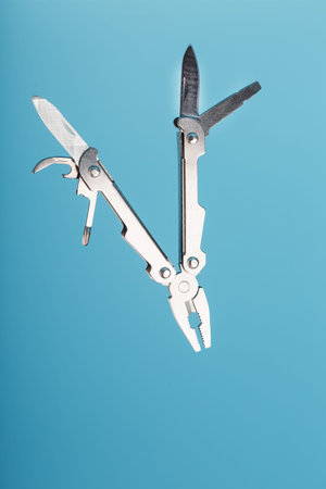 The multitool multi-function tool hovers on a blue background. The concept of an expanded multi-tool...