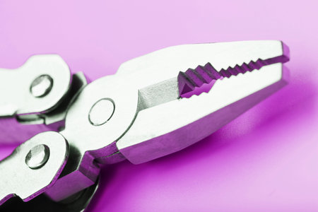Multitool is a multi-functional tool on a pink background. The concept of an open, flying multi-tool with free space. Clipping path included isolateの写真素材